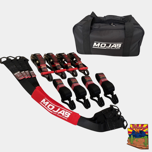Set of four black and red 2-inch by 10-foot ratchet tie-down straps with closed hooks, four 2-inch by 39-inch axle tie-down straps, and a black Mojab off-road gear storage bag.